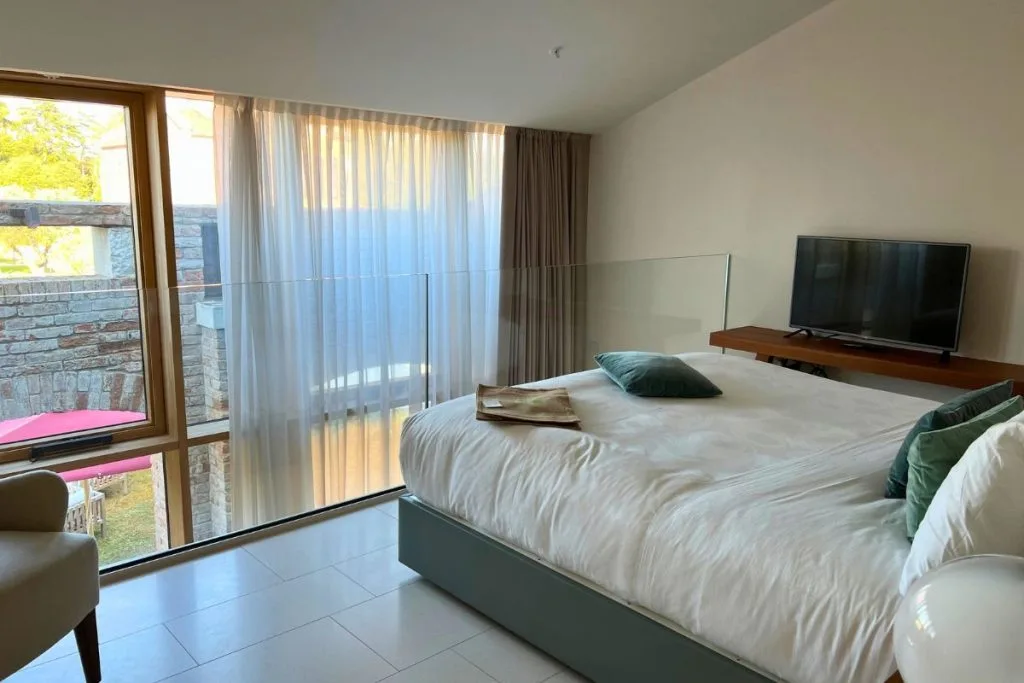 La Maisonette Loft bedroom at JW Marriott Venice with glass railing over the sitting area below