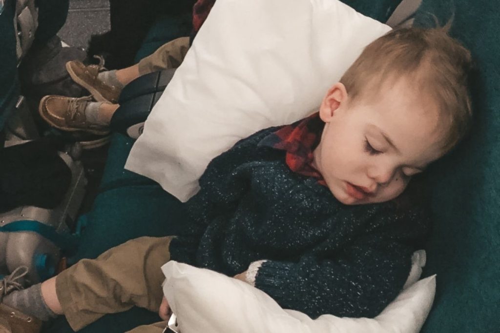 Two-year-old twin propped up on pillows during airplane landing after 16-hour wake time