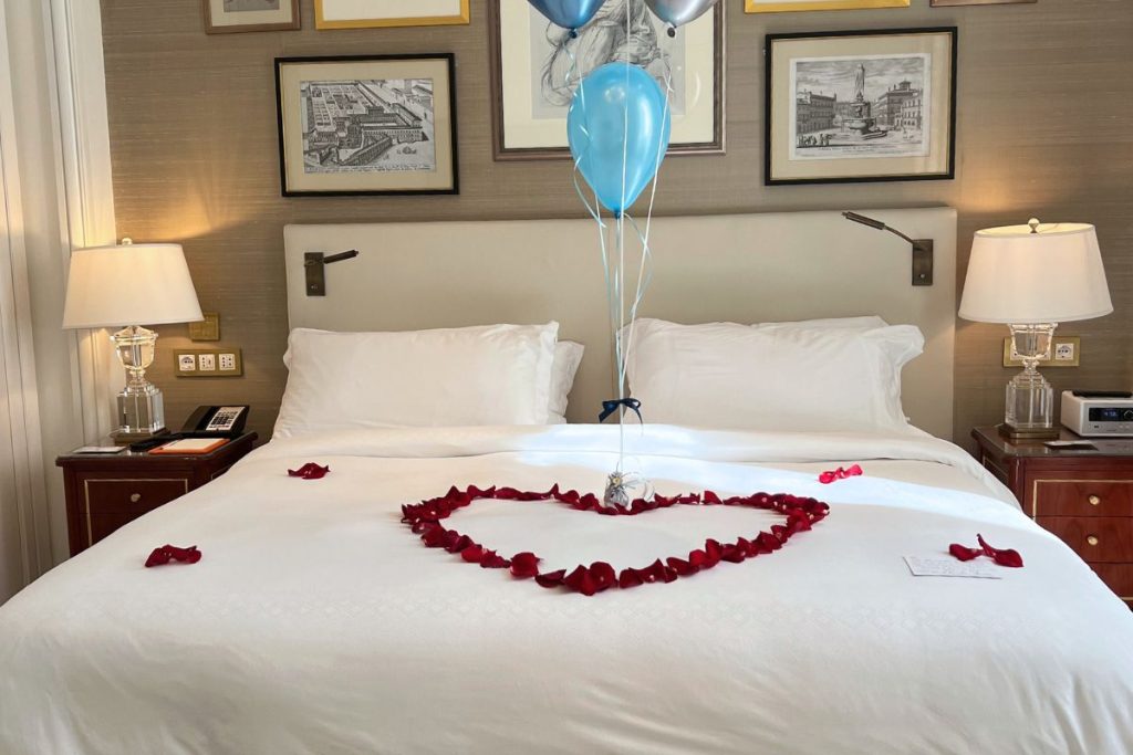 St. Regis Rome suite king bed with luxury linens and Acqua di Parma toiletries visible