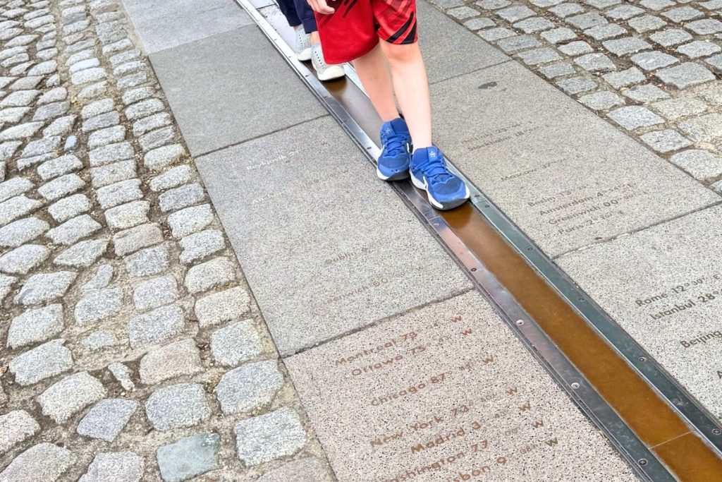 Family standing at Prime Meridian Greenwich - standing in two hemispheres