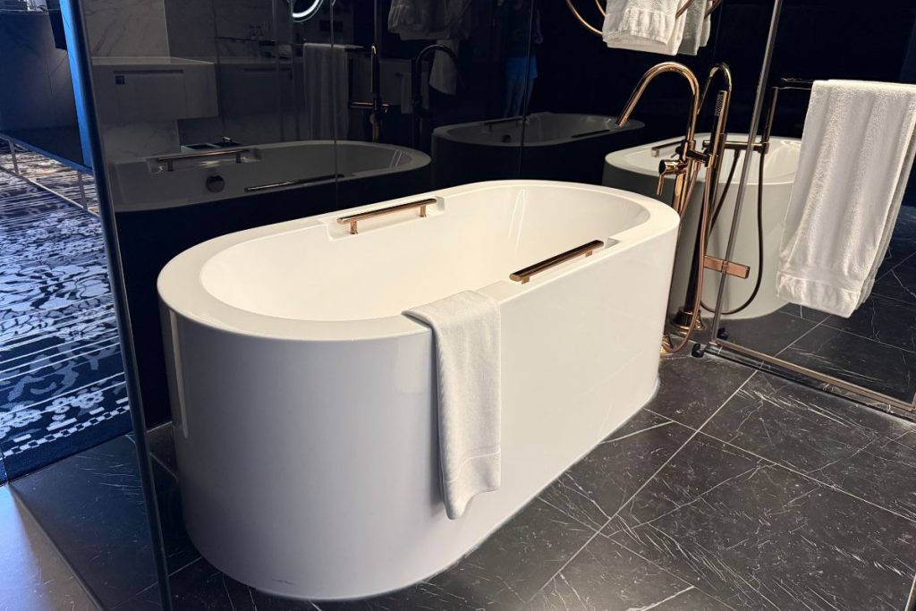 Le Méridien Taichung bathroom with separate soaking tub walk-in shower and glass wall visible from entry corridor