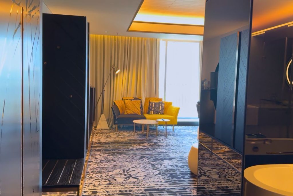 Le Méridien Taichung room entry corridor with dark wood cabinets and glass enclosed bathroom