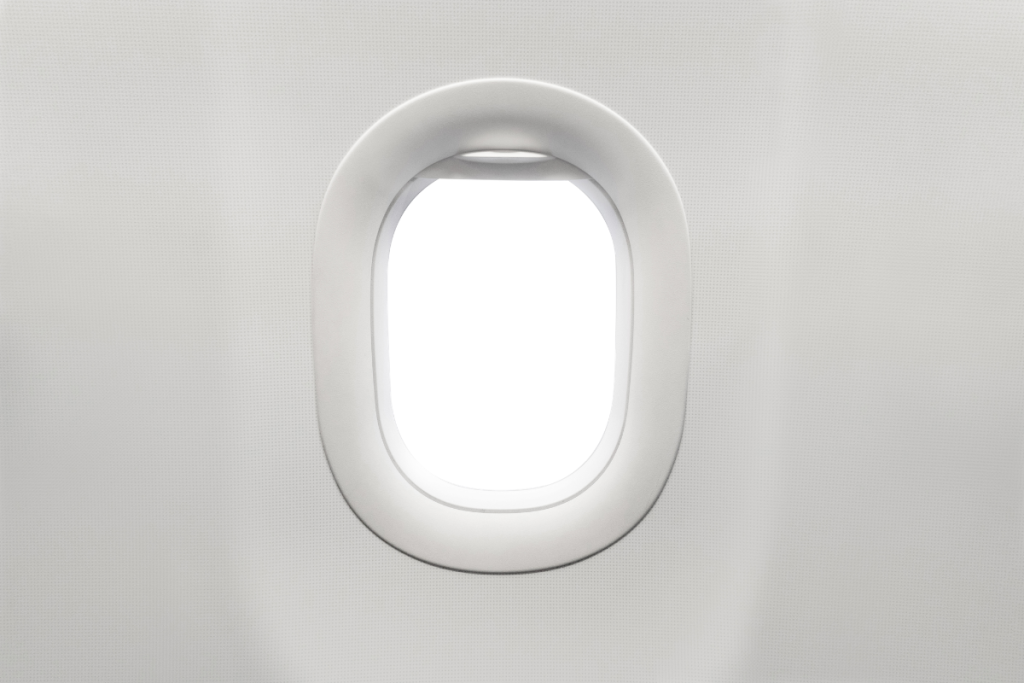 Baby playing with airplane window shade on daytime flight — free baby entertainment