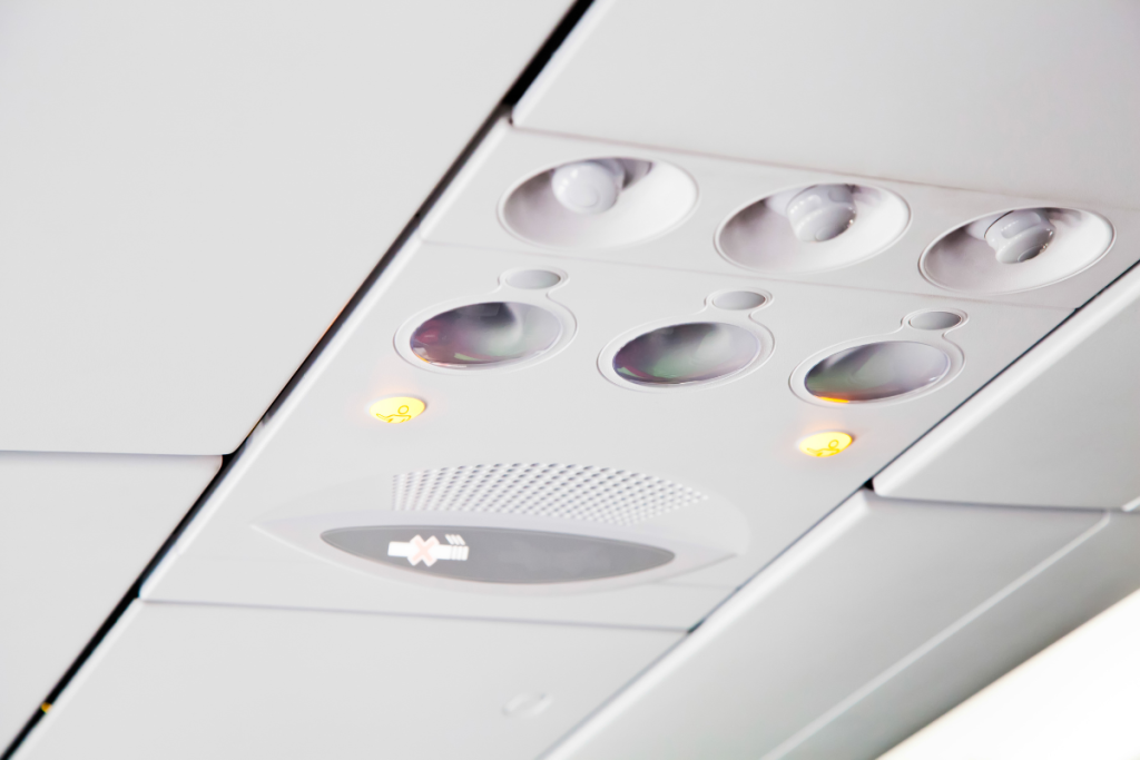 Baby looking at airplane reading light in dark cabin — simple entertainment for young infants