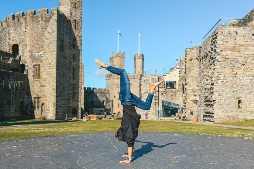 Doing a handstand in empty Caernarfon Castle courtyard in June β proof that arriving early means having the place to yourself